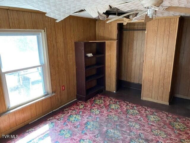 unfurnished bedroom featuring wood walls