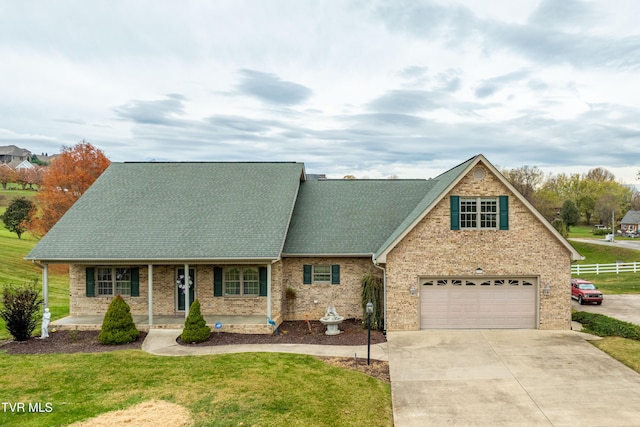 view of front of house with a front lawn, covered porch, and a garage