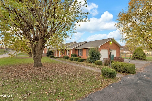 ranch-style home featuring a garage and a front lawn