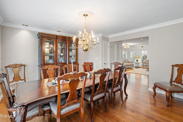 dining area featuring hardwood / wood-style flooring, ornamental molding, and a chandelier