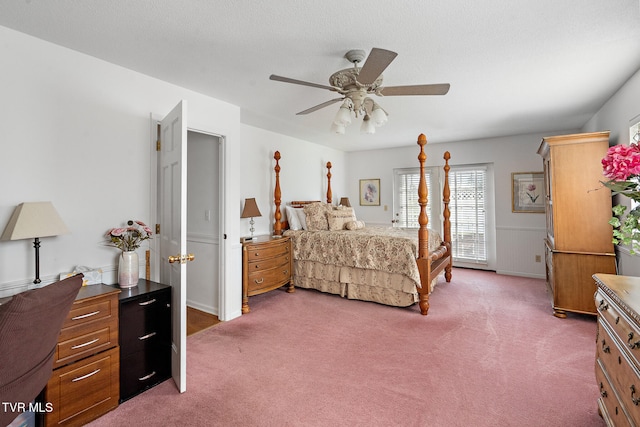 carpeted bedroom with ceiling fan and a textured ceiling