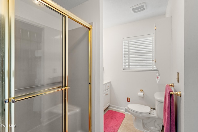 bathroom with tile patterned floors, vanity, toilet, and a shower with door