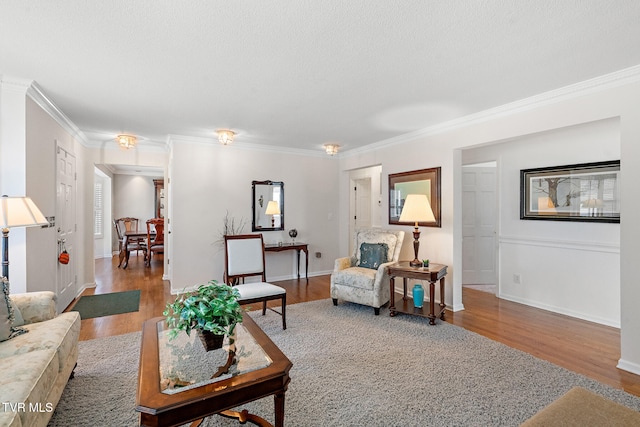 living room with a textured ceiling, hardwood / wood-style flooring, and ornamental molding