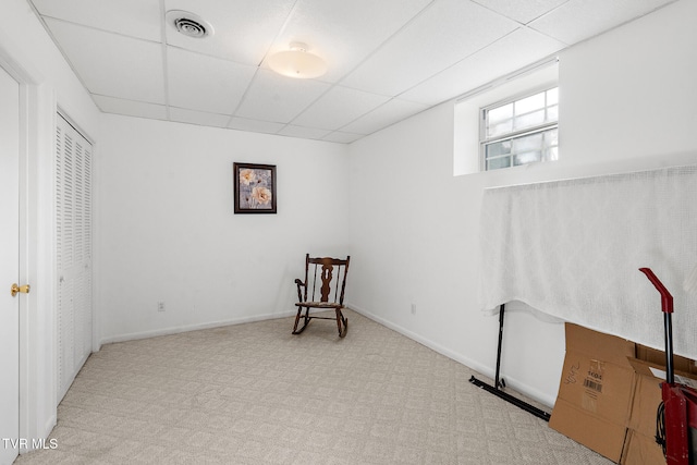 sitting room featuring a paneled ceiling and light colored carpet