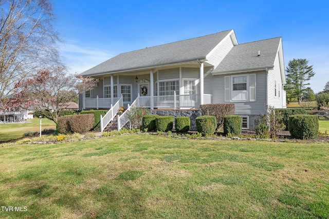 view of front facade featuring ceiling fan, covered porch, and a front yard