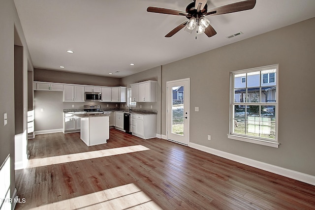 kitchen featuring white cabinetry, stainless steel appliances, a center island, light hardwood / wood-style flooring, and sink