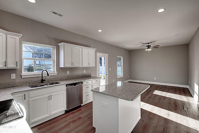 kitchen featuring ceiling fan, a kitchen island, stainless steel dishwasher, sink, and white cabinets