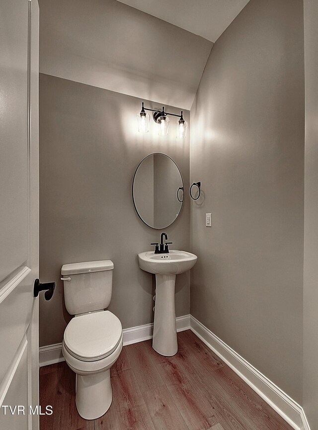 bathroom featuring toilet, lofted ceiling, and hardwood / wood-style flooring