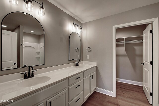 bathroom featuring a shower, hardwood / wood-style floors, and vanity