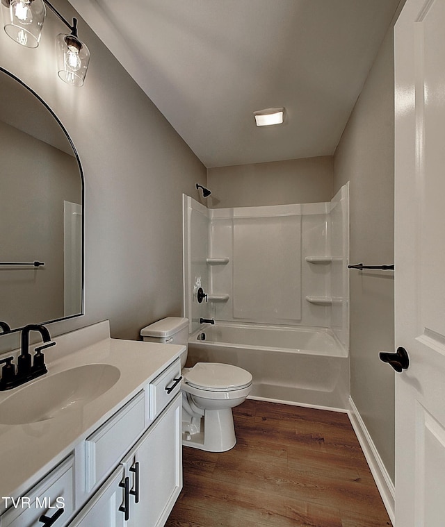 full bathroom with toilet, vanity,  shower combination, and hardwood / wood-style floors