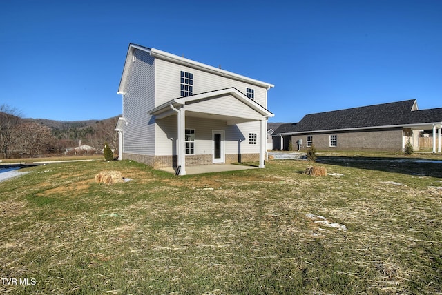 rear view of property featuring a patio area and a lawn