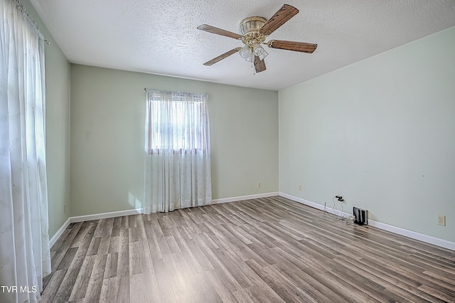 unfurnished room with ceiling fan, light hardwood / wood-style floors, and a textured ceiling