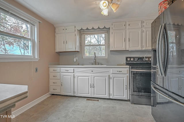 kitchen with sink, white cabinetry, stainless steel appliances, and a wealth of natural light