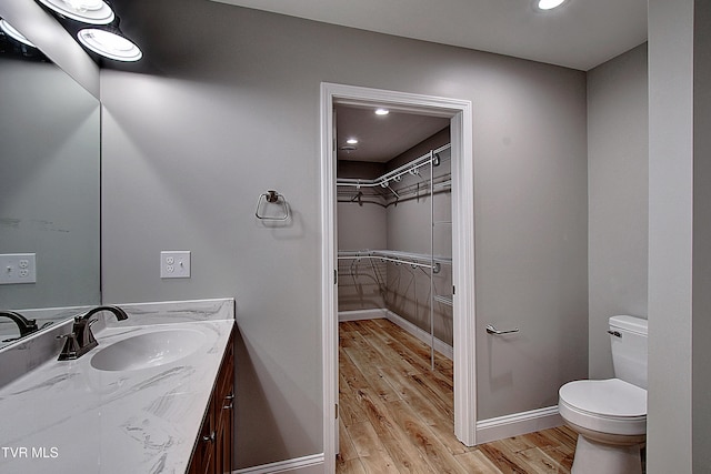 bathroom with hardwood / wood-style floors, vanity, and toilet