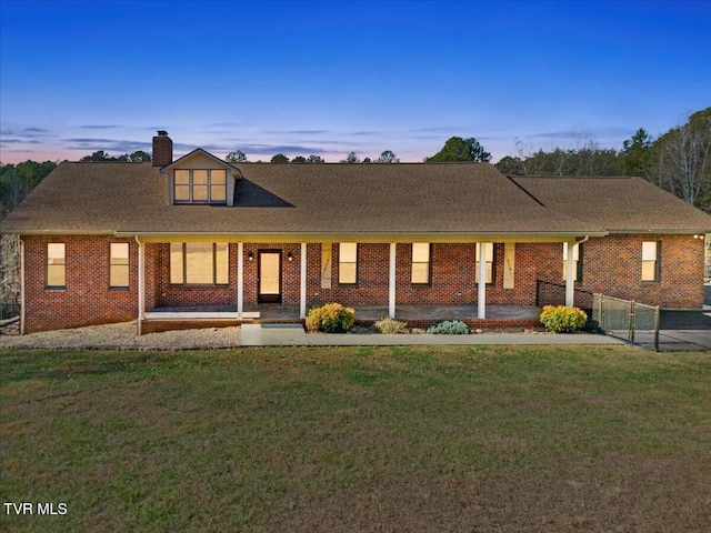 view of front of property featuring covered porch and a lawn