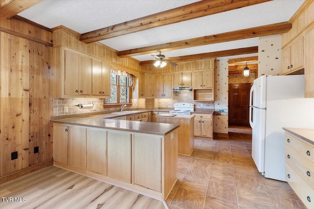 kitchen with decorative backsplash, white appliances, ceiling fan, sink, and wood walls