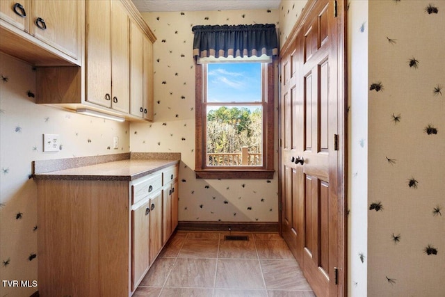 kitchen with light brown cabinets and light tile patterned floors