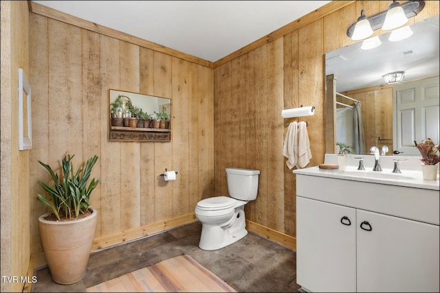 bathroom with wooden walls, baseboards, walk in shower, toilet, and vanity