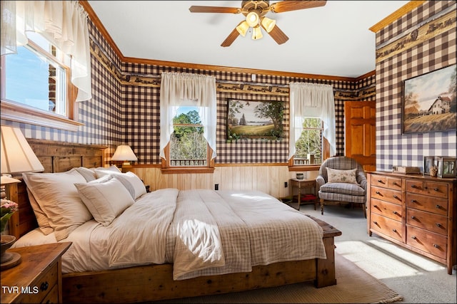 carpeted bedroom featuring multiple windows, wallpapered walls, and ceiling fan