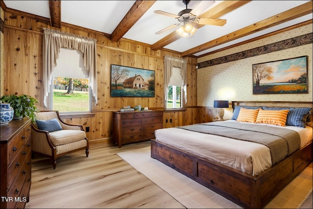 bedroom featuring light wood finished floors, beamed ceiling, multiple windows, and wallpapered walls