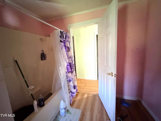 bathroom with hardwood / wood-style floors and crown molding