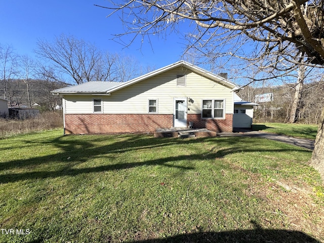 rear view of house featuring a yard