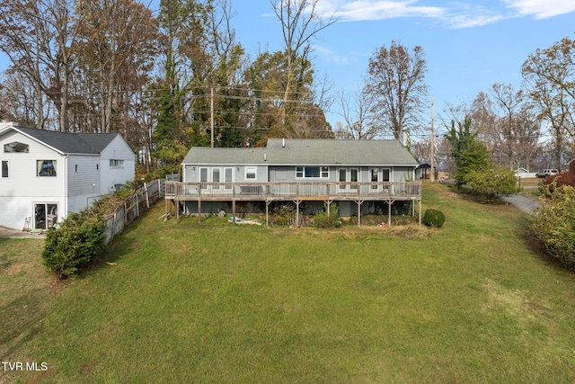 rear view of house with a deck and a yard