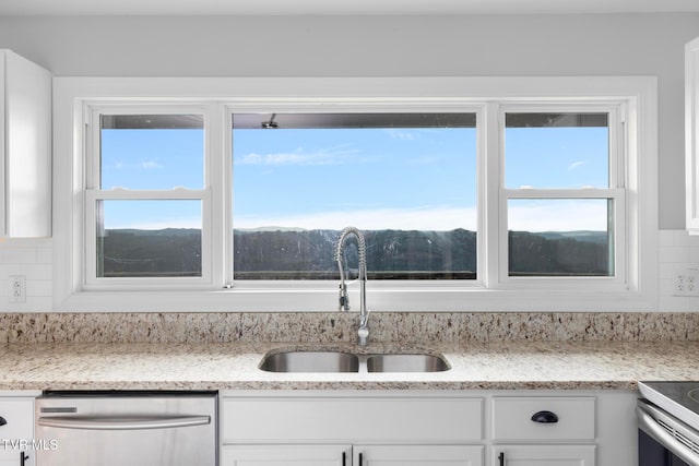 kitchen with backsplash, dishwasher, white cabinetry, and sink