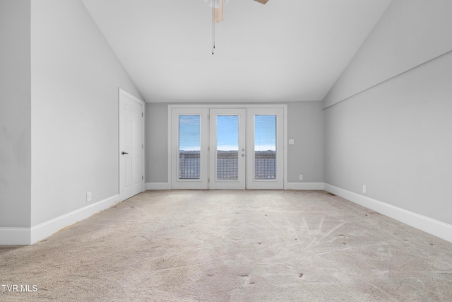 spare room featuring light colored carpet, ceiling fan, and lofted ceiling