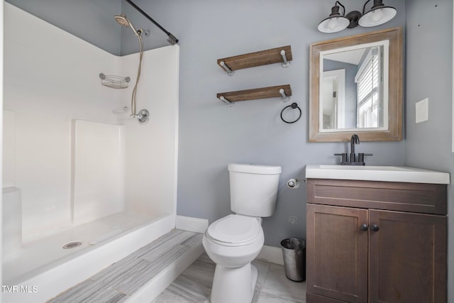 bathroom featuring vanity, toilet, and walk in shower