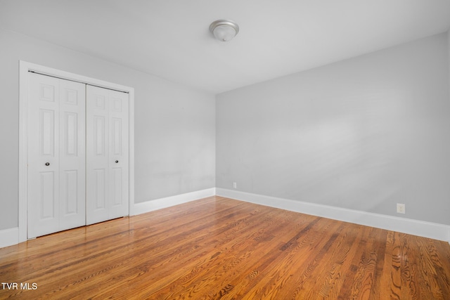 unfurnished bedroom with hardwood / wood-style flooring and a closet