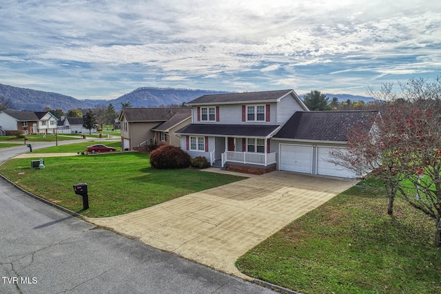 front of property with a front yard, a mountain view, a garage, and a porch