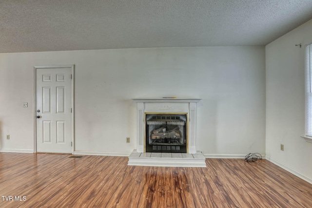 unfurnished living room with hardwood / wood-style floors and a textured ceiling