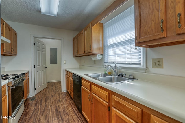 kitchen featuring dishwasher, dark wood-type flooring, sink, gas range oven, and a textured ceiling