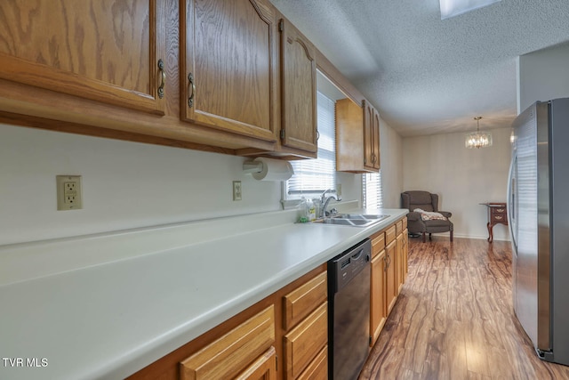 kitchen featuring sink, light hardwood / wood-style flooring, a notable chandelier, dishwasher, and stainless steel refrigerator