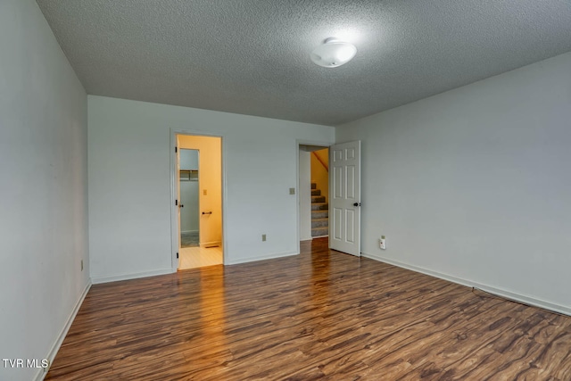 spare room with dark hardwood / wood-style flooring and a textured ceiling