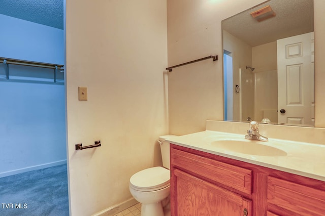 bathroom with vanity, toilet, a shower, and a textured ceiling