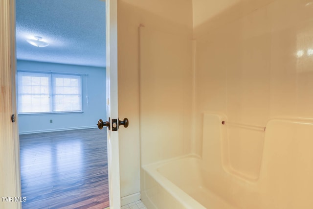 bathroom with wood-type flooring and a textured ceiling