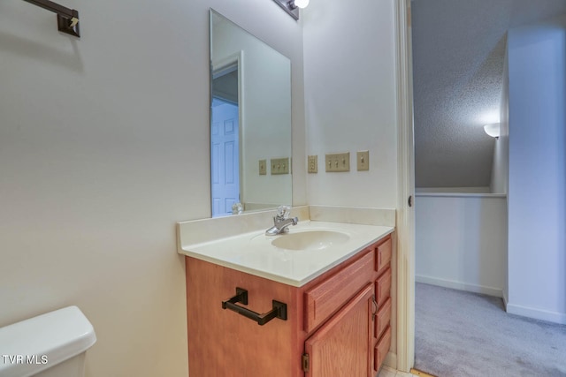 bathroom with vanity, a textured ceiling, and toilet