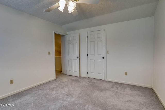 unfurnished bedroom with a textured ceiling, ceiling fan, and light carpet