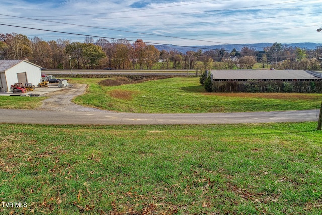 exterior space with a garage, a mountain view, and a lawn