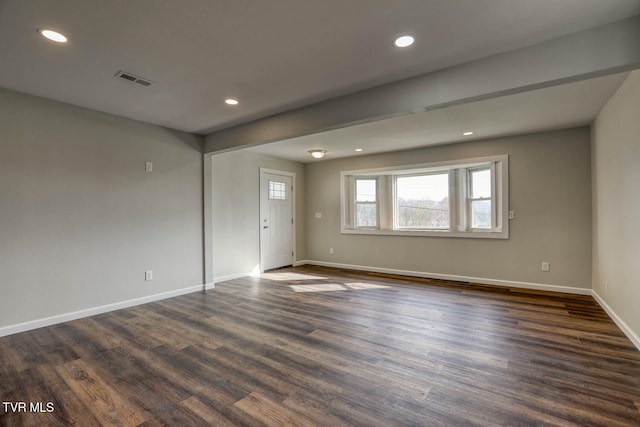 spare room featuring recessed lighting, dark wood-style flooring, visible vents, and baseboards