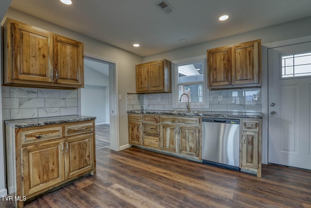 kitchen with visible vents, brown cabinetry, dark wood-style floors, stainless steel dishwasher, and a sink