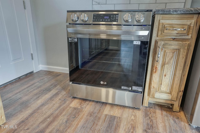 interior details featuring dark countertops, baseboards, and wood finished floors