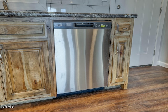 details featuring dishwasher, dark wood-type flooring, dark countertops, and a sink