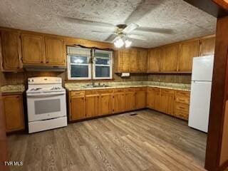 kitchen featuring ceiling fan, light hardwood / wood-style flooring, white appliances, and sink