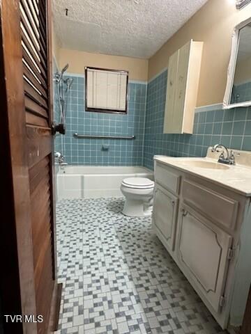 full bathroom featuring a textured ceiling, toilet, vanity, tile walls, and tiled shower / bath