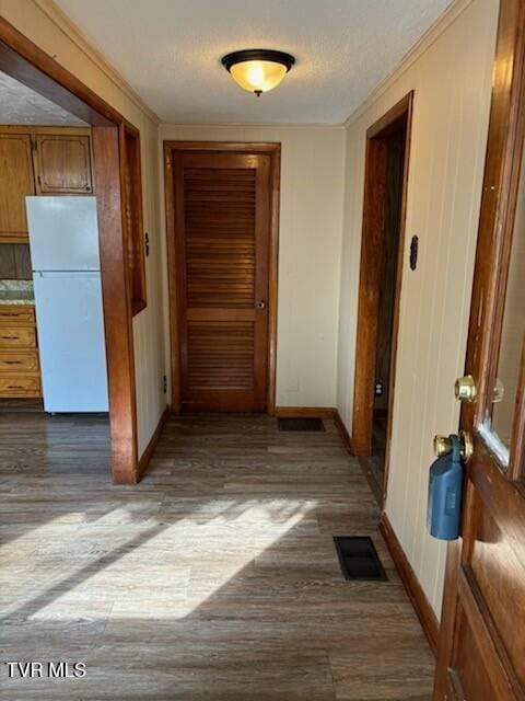 corridor with dark hardwood / wood-style flooring and a textured ceiling