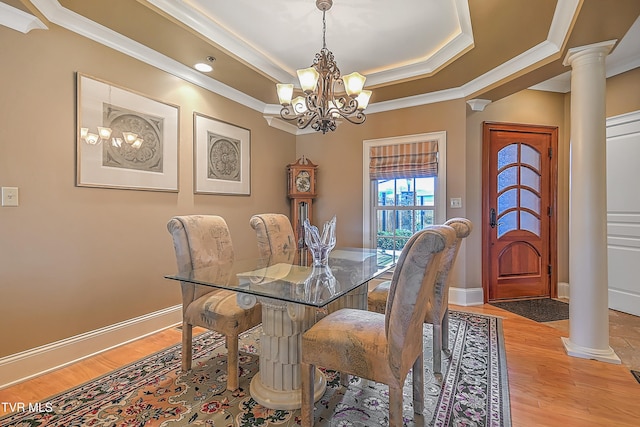 dining area with a chandelier, light hardwood / wood-style flooring, ornate columns, and ornamental molding