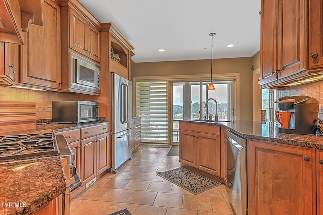 kitchen featuring decorative backsplash, sink, hanging light fixtures, and appliances with stainless steel finishes